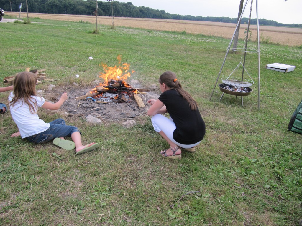 Deux jeunes filles grillent leurs chamallows au dessus du feu de camp